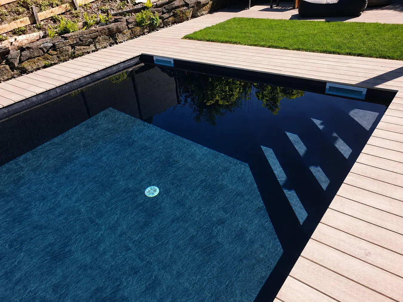 Dunkler Pool mit Holzdeck – Pool Service Stritt